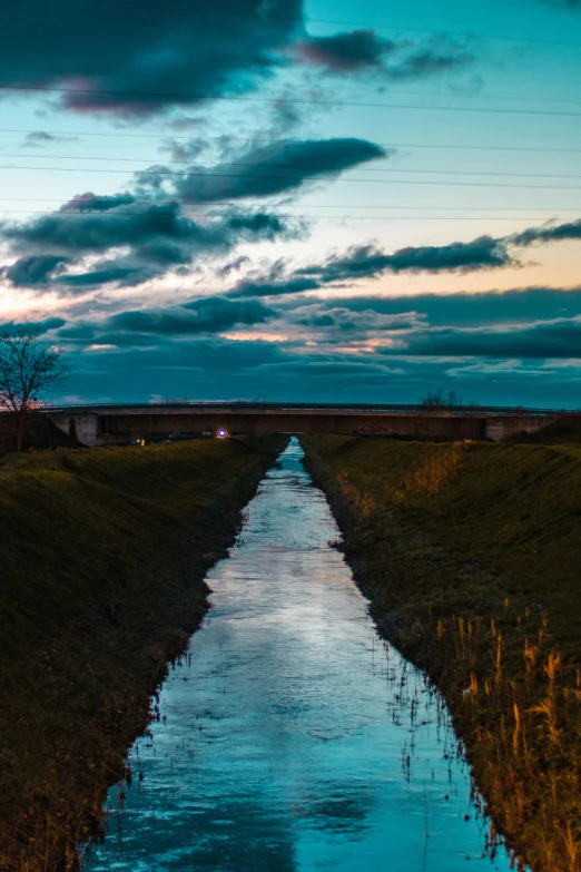 the long blue water is next to a field