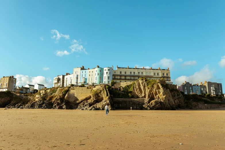 a couple walking on the beach by some houses