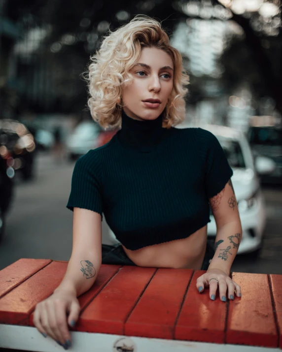 a woman in black crop top leaning over table