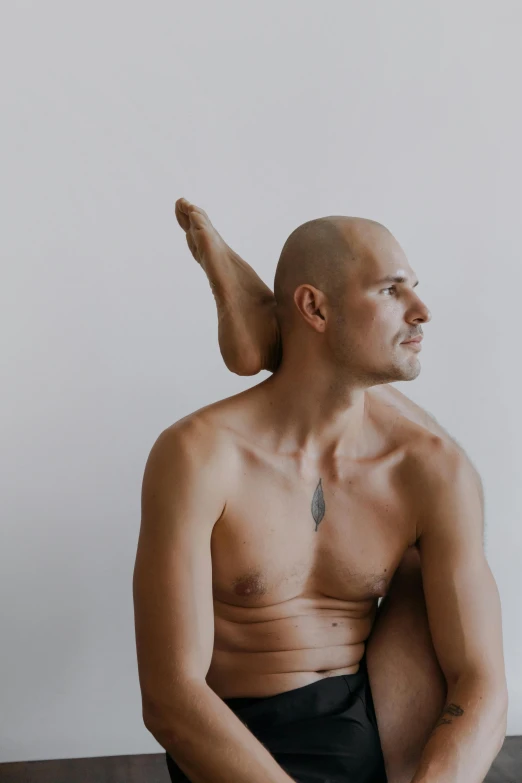 a bald man sitting on top of a brown table