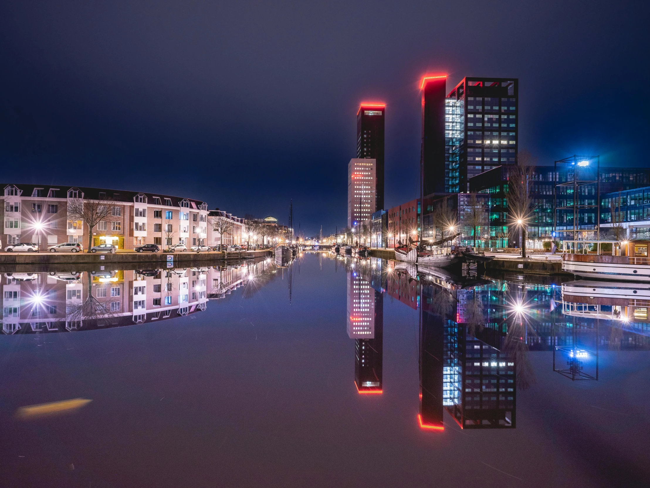 some buildings lights reflecting on water water and buildings