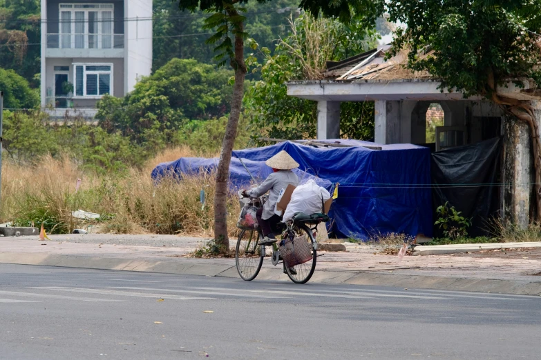 a man riding on the back of a bicycle down a street