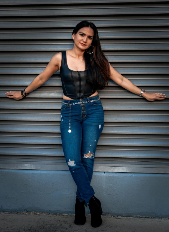 a woman standing in front of a grey wall