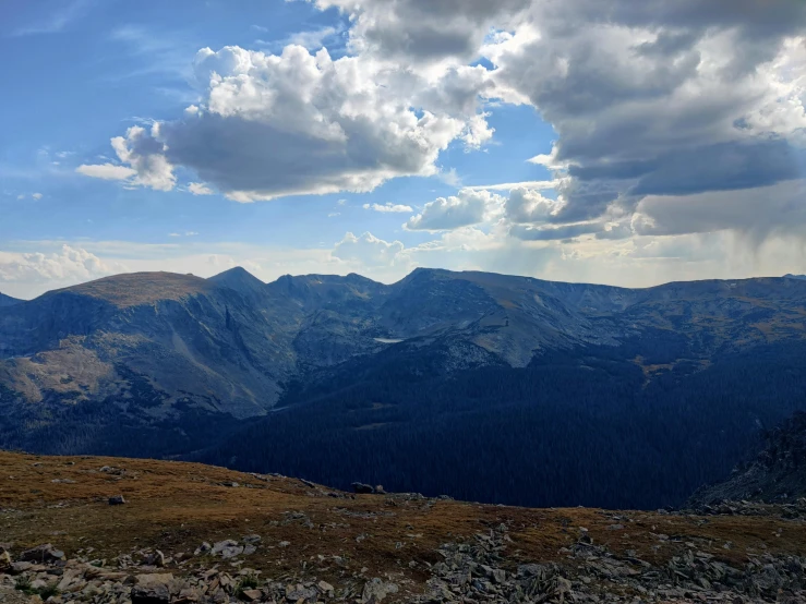 a man on a mountain top looking down at mountains