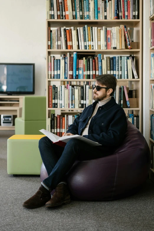 the man is sitting in a bean bag chair