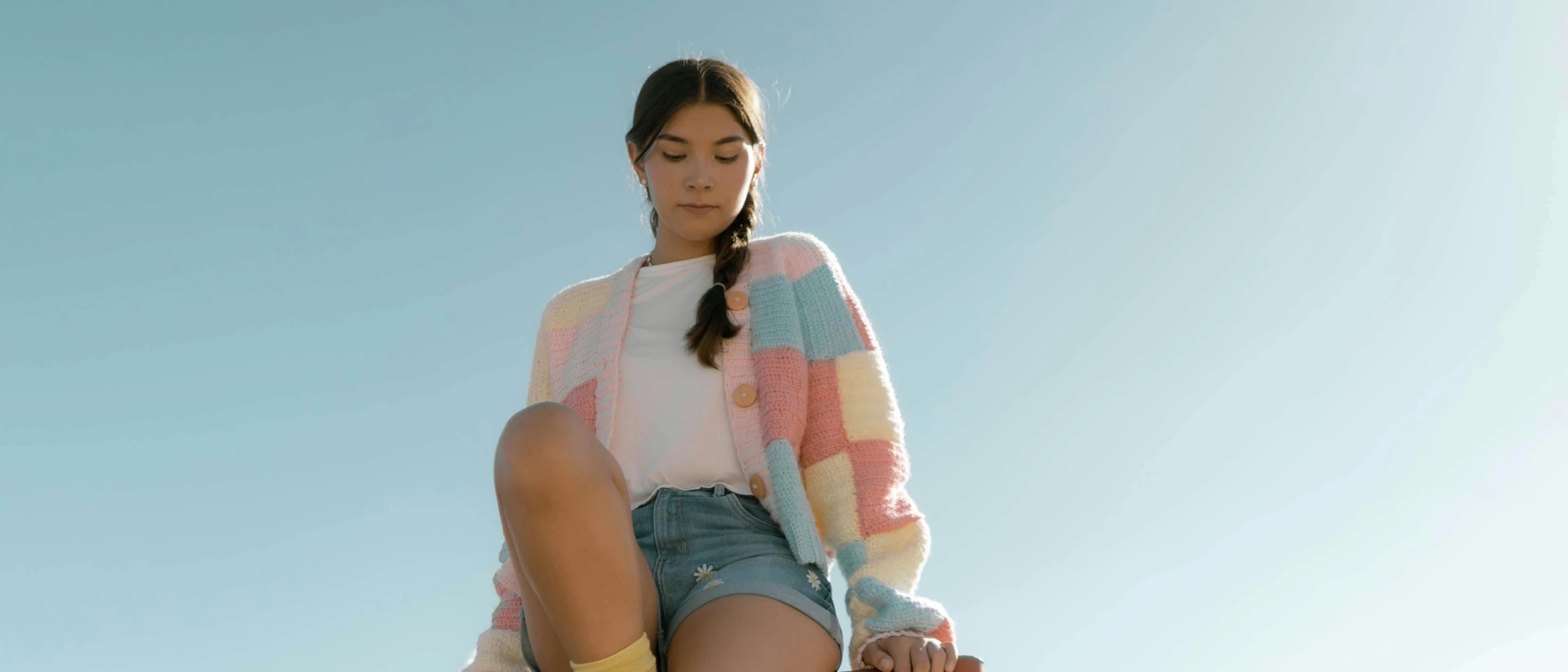 a girl sitting in a high chair on a skateboard