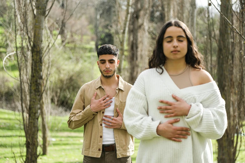 a couple with one woman in the middle holding their hands together