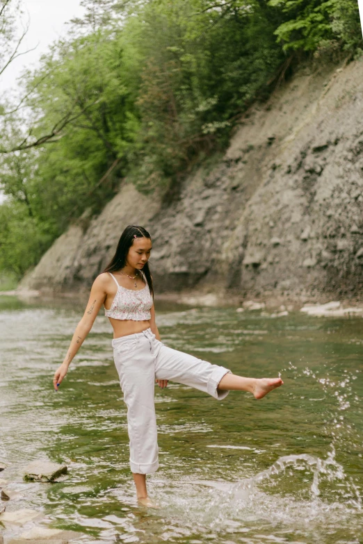 a woman standing in the water near a shore