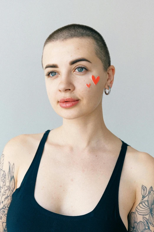 girl with broken eye on her cheek wearing two pairs of earrings