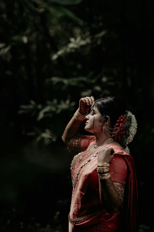 a woman dressed in a red saree holding a cellphone