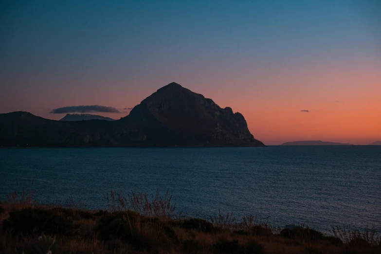 the sunset lights up the sky near some mountains