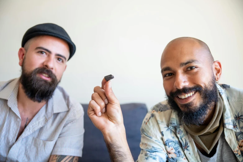 two people, one man smiling and one with a pen