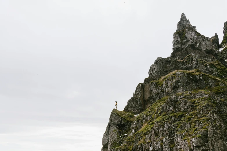 a group of people standing on the edge of a rocky cliff