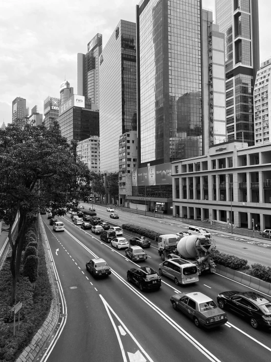 traffic moving along a busy highway in front of tall buildings