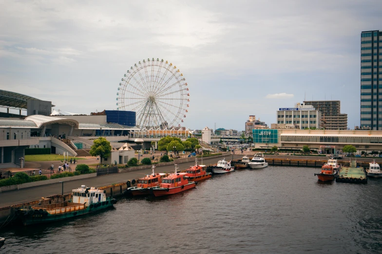 boats on the water with a ferris wheel in the background