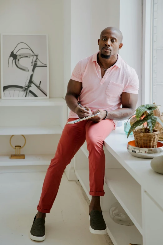 a man is seated on a window sill with his feet propped up