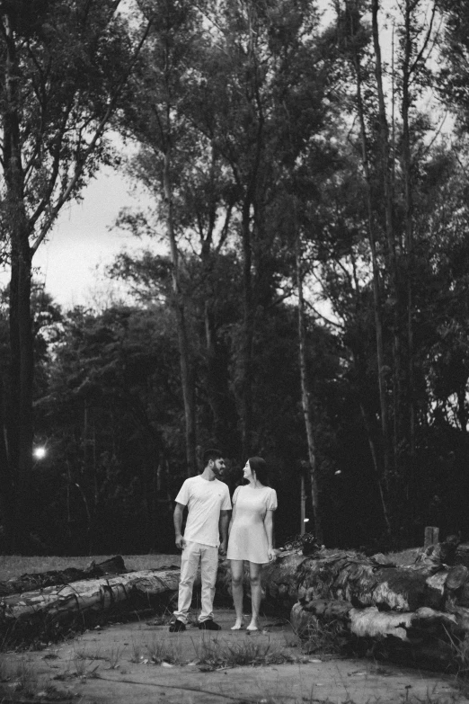 two people standing in front of a few trees
