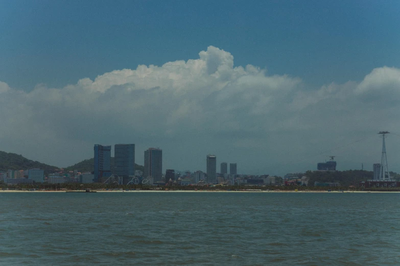 a large body of water with some buildings and clouds in the background