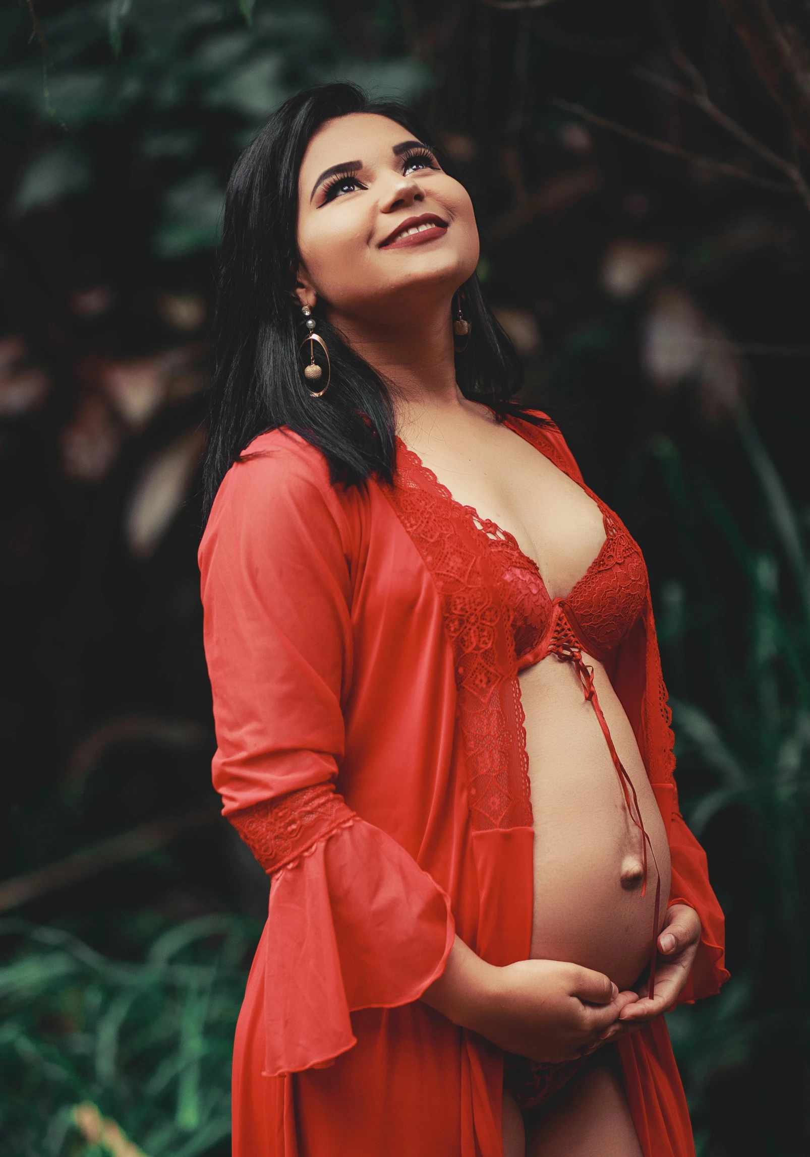 pregnant woman with a red top posing for a po