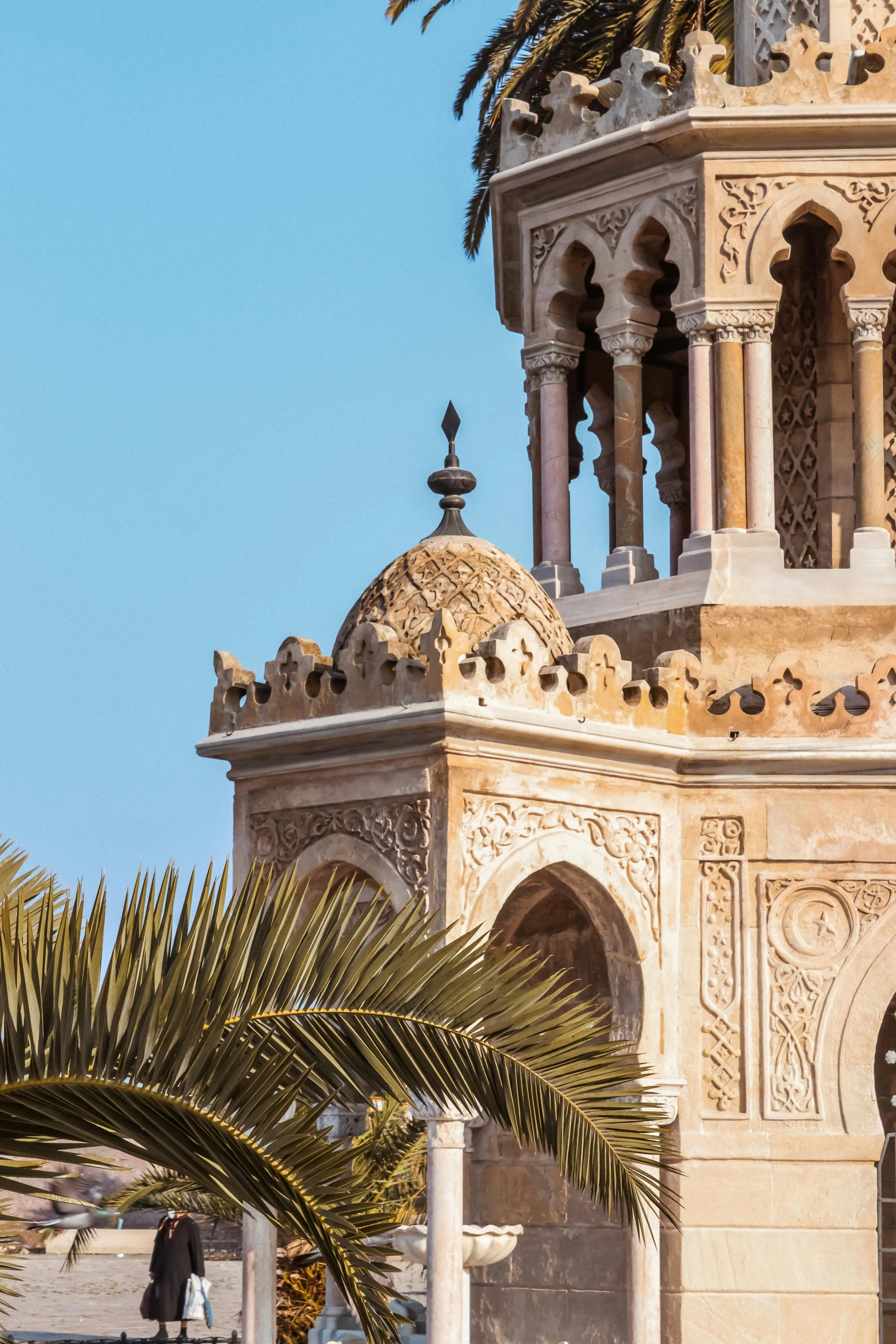 a tall dome with a palm tree in the foreground