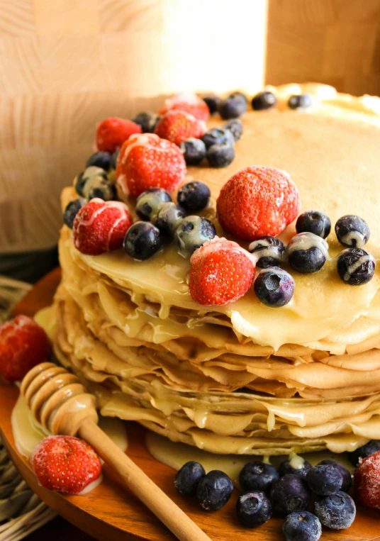 the stack of pancakes is covered with fresh berries