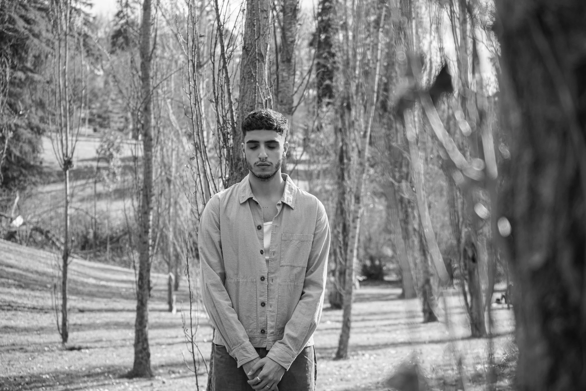 a man in a shirt standing in the middle of a park