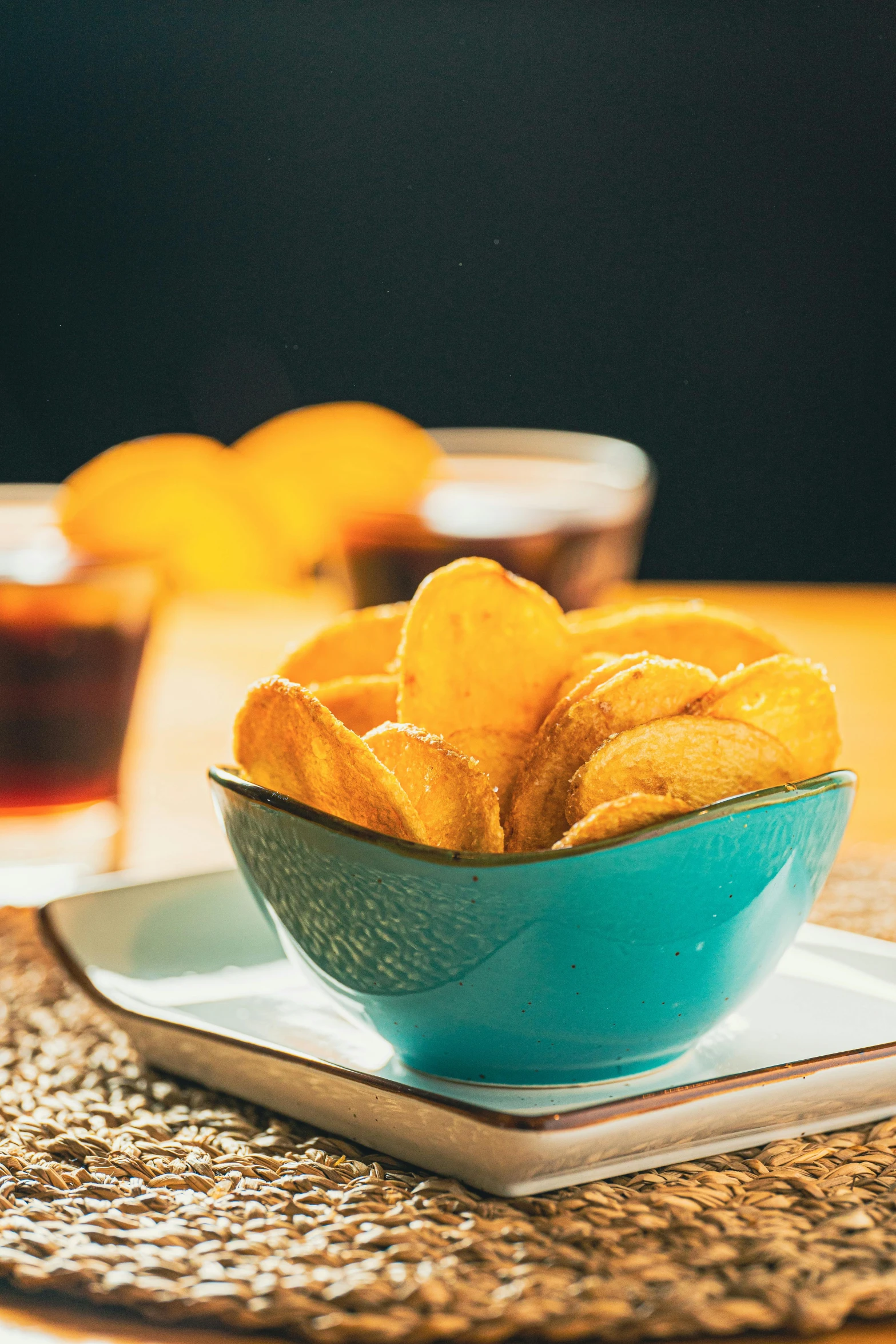 a blue bowl filled with cut up food next to a cup of tea