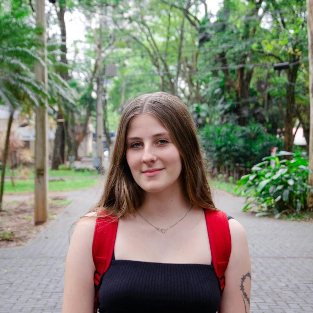 young woman with long hair wearing a black tank top in public