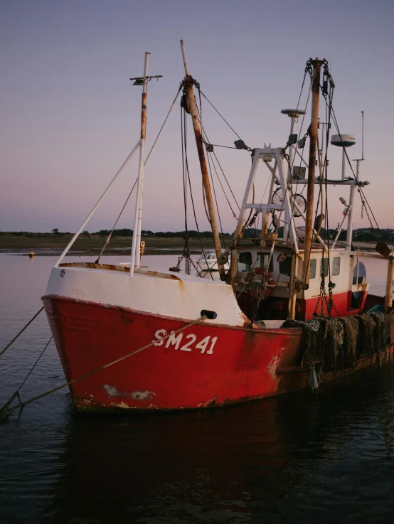 red and white boats sit anchored at a pier