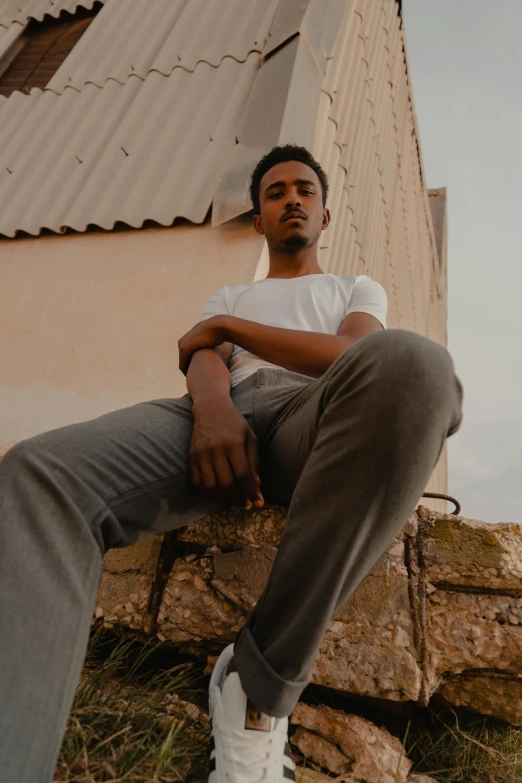 a man sitting on a rock next to a building