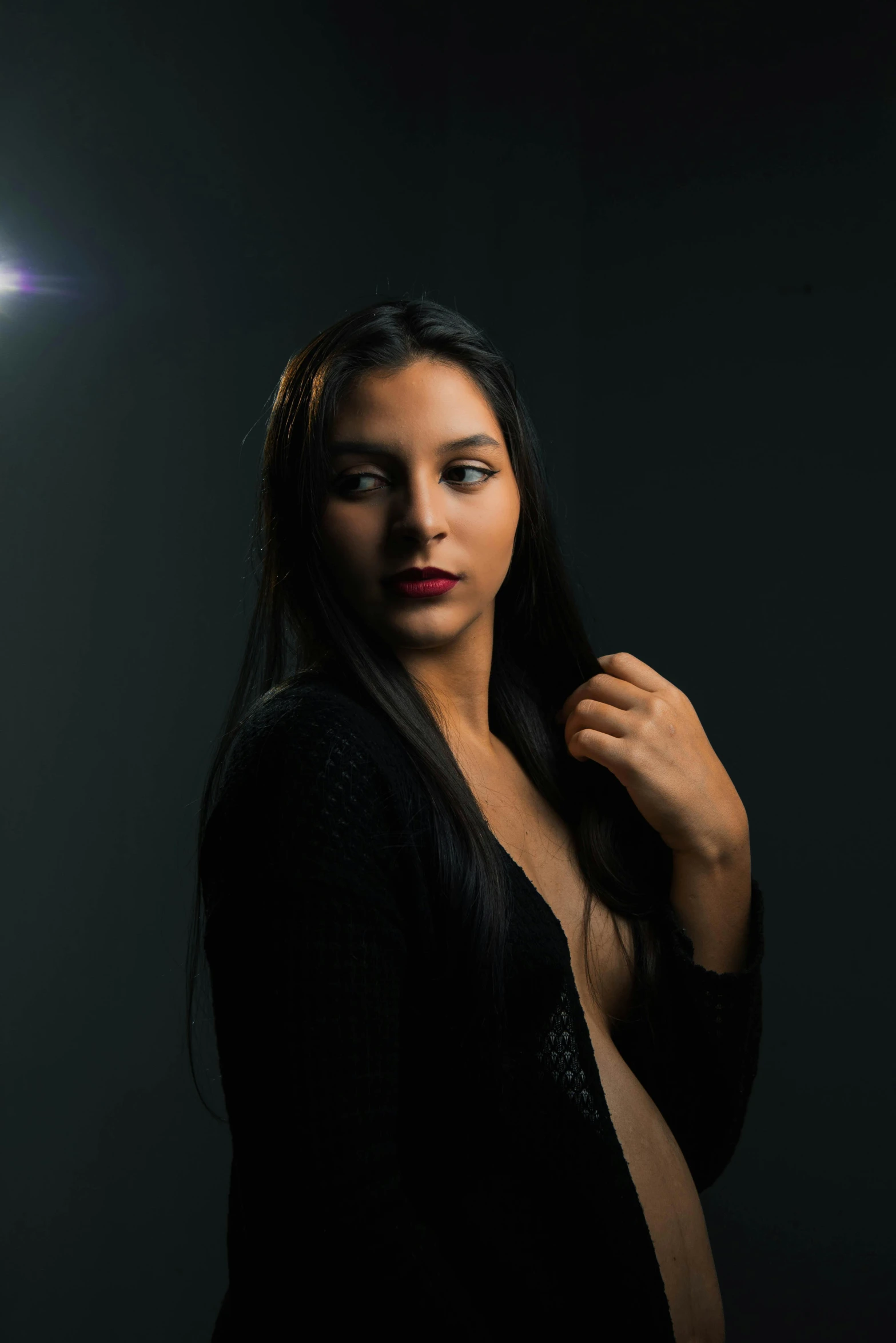 a woman is holding her hair in front of a light