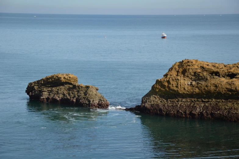 an image of rocks on the ocean with some water around it