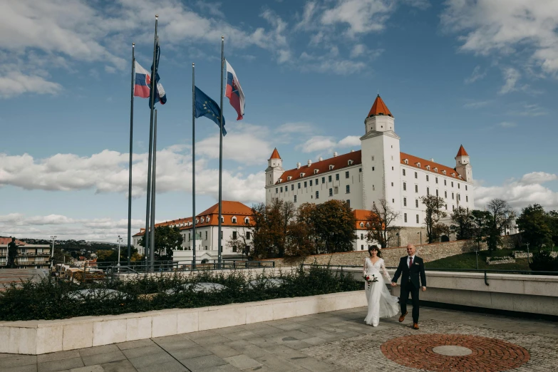 a bride and groom are standing outside a large building
