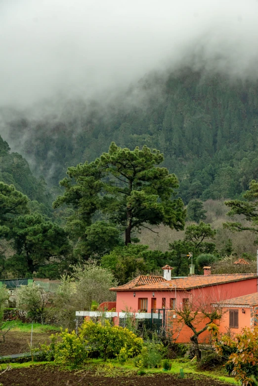 a red house on a hill surrounded by a valley