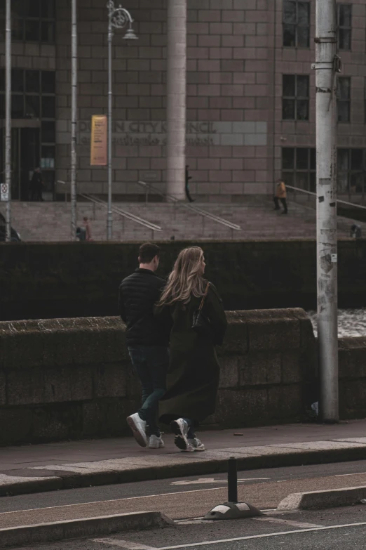 a couple running past a stop sign in a city