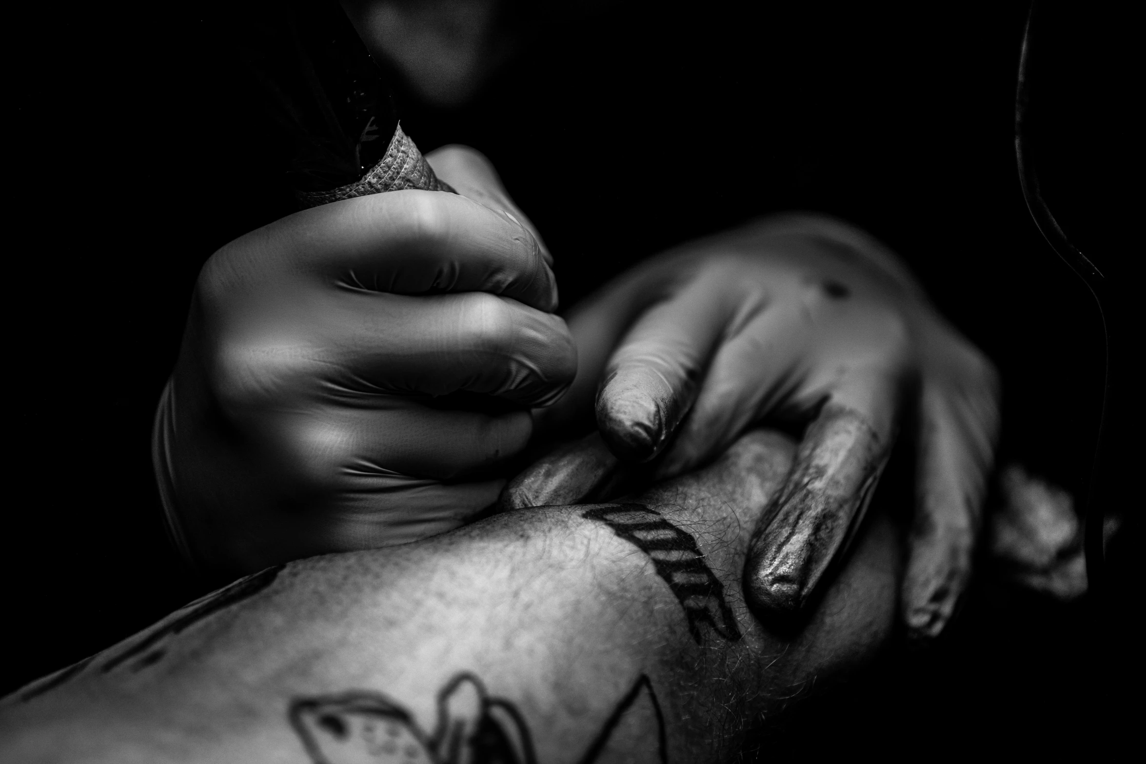 a person holding the fingers of another person with tattoos