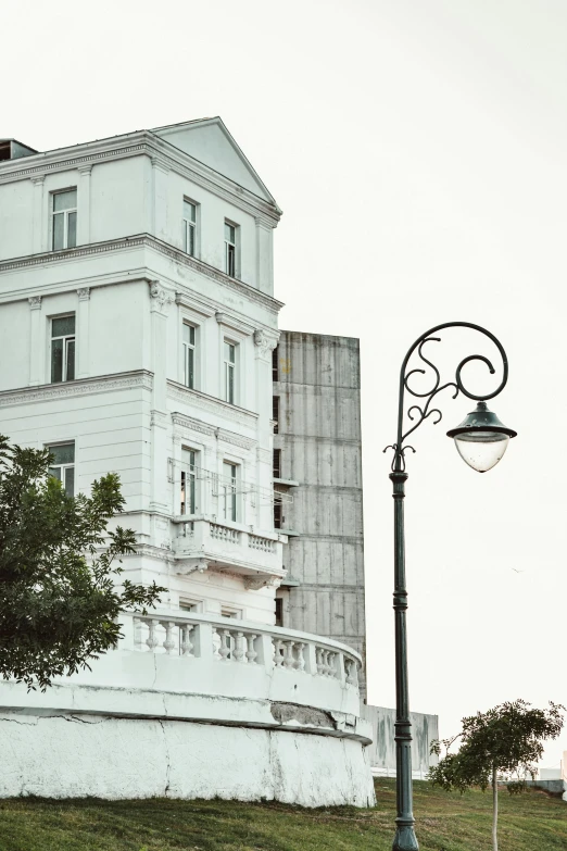 a street light stands next to a white building