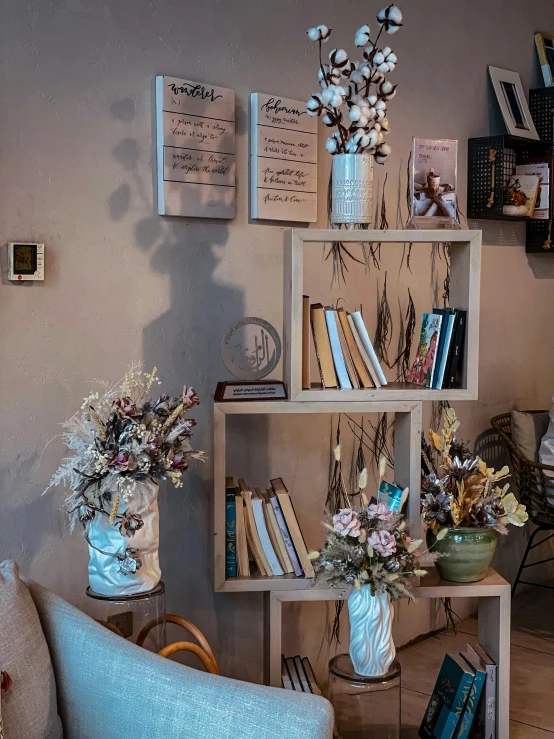 books, flowers, and other decorations on a wood shelf