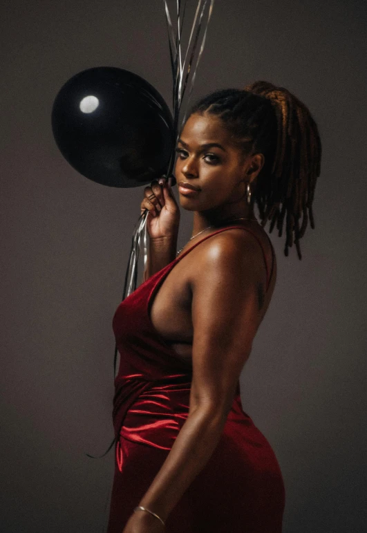 a woman in a red dress holds some balloons