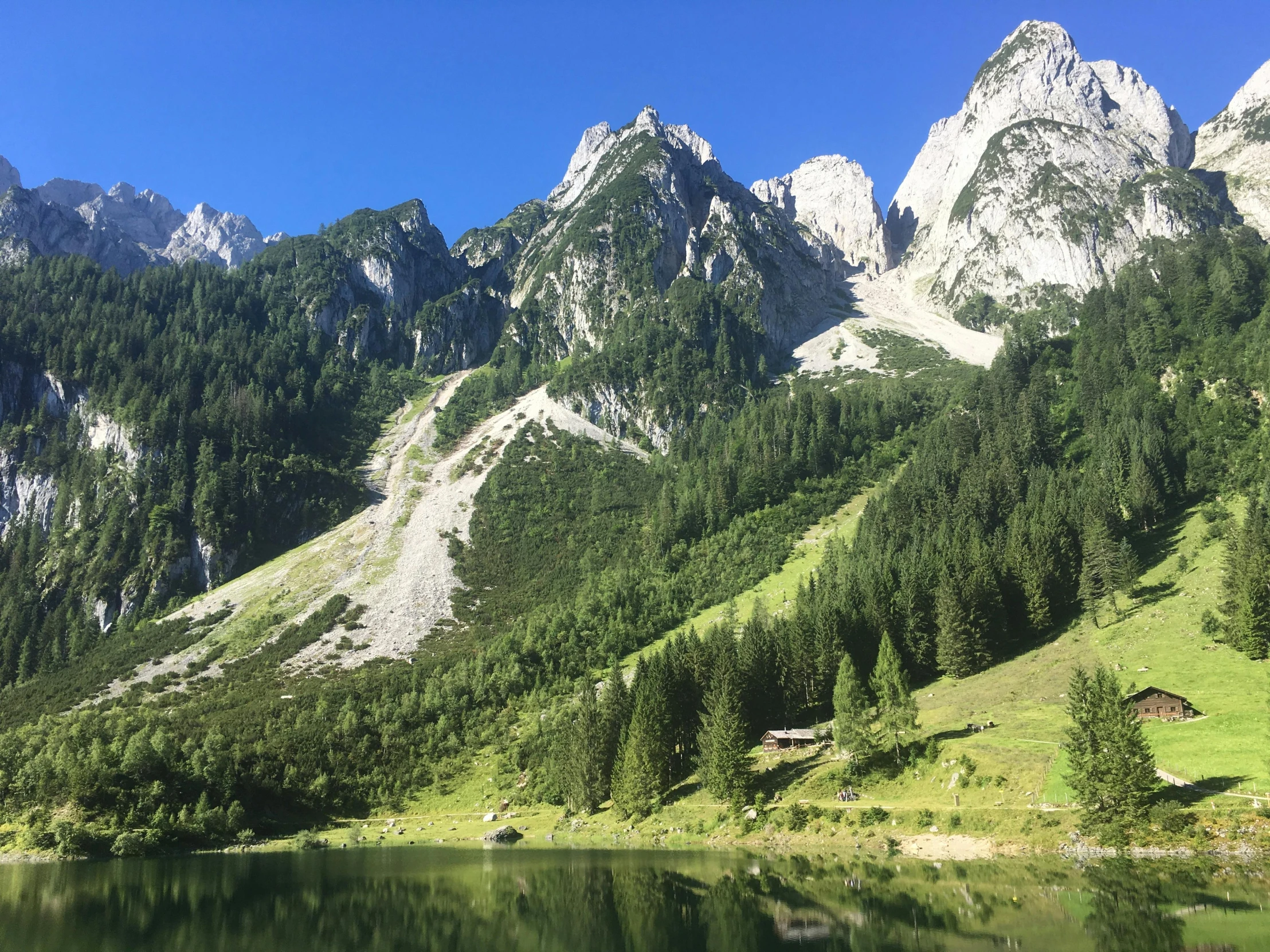 a lake in front of some mountains on a sunny day