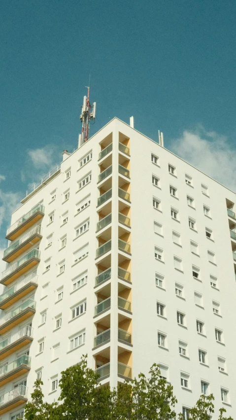 a tall white building is against a blue sky