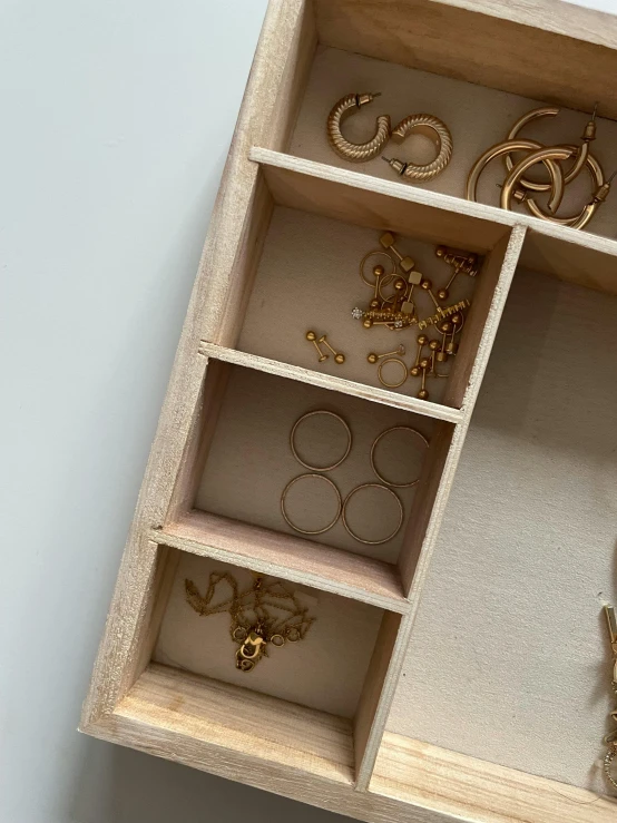 an open wooden box filled with various types of jewelry