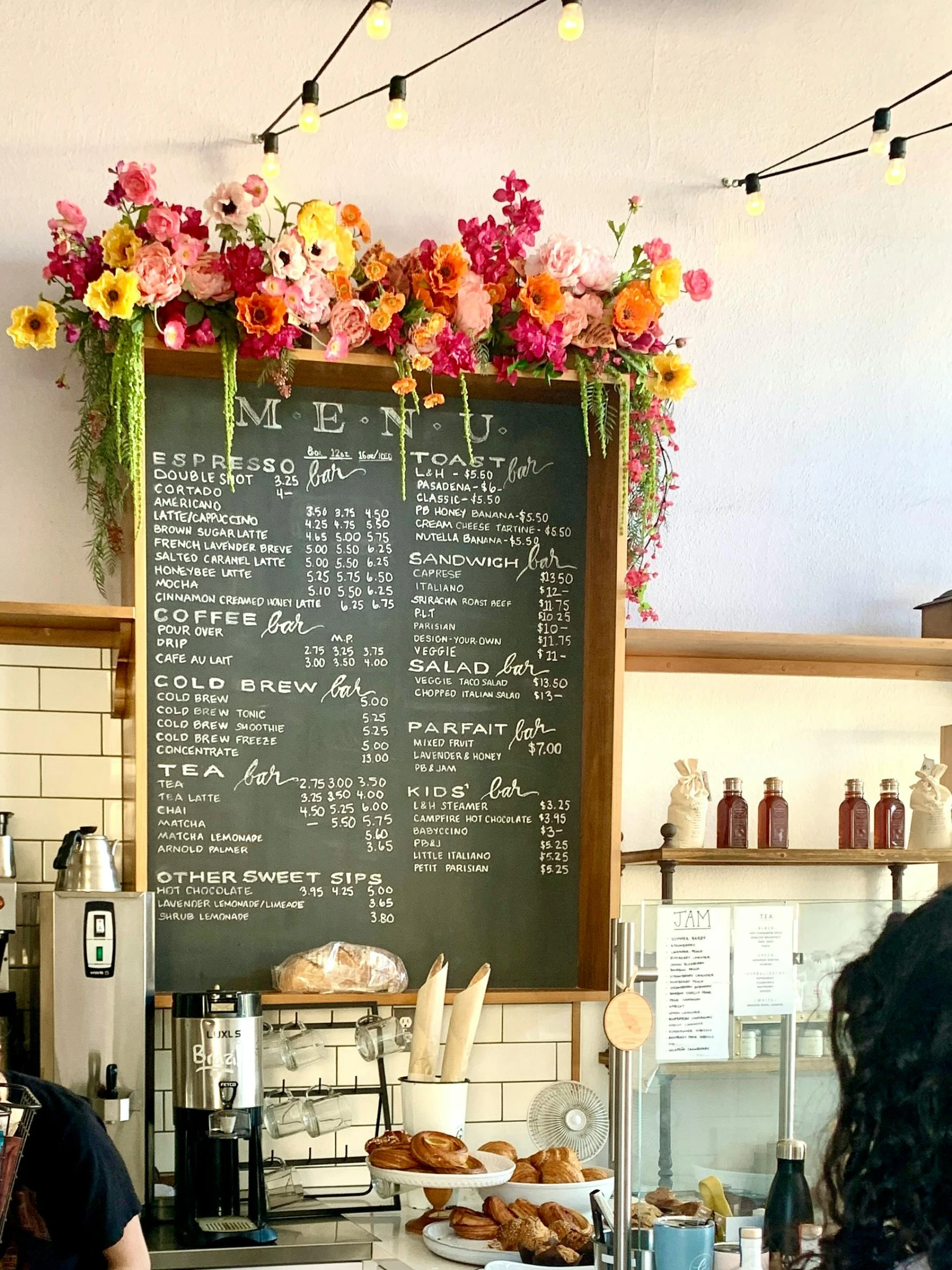 a chalkboard has flowers all over it with bunnies at the counter