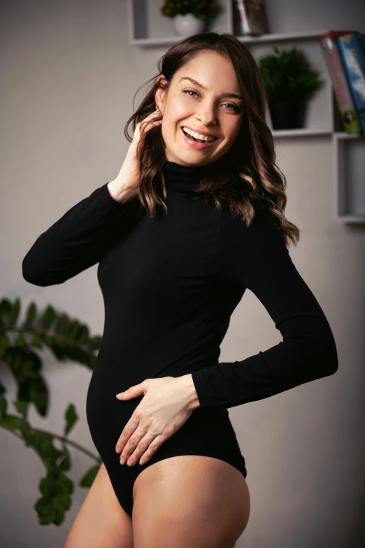 a woman poses in a tight, black body suit