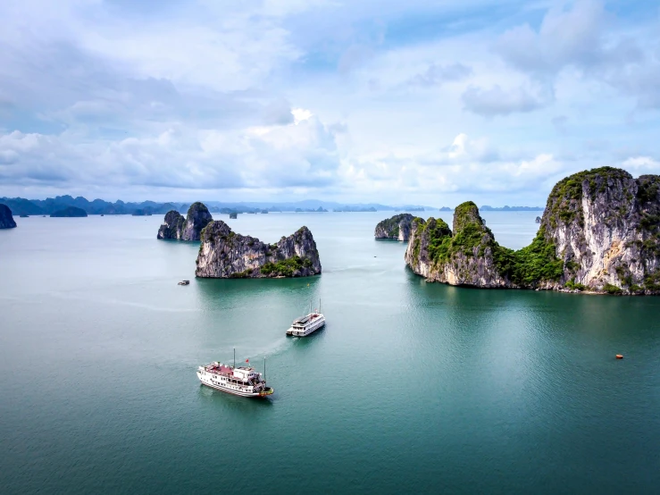 boats sailing near some green hills and cliffs