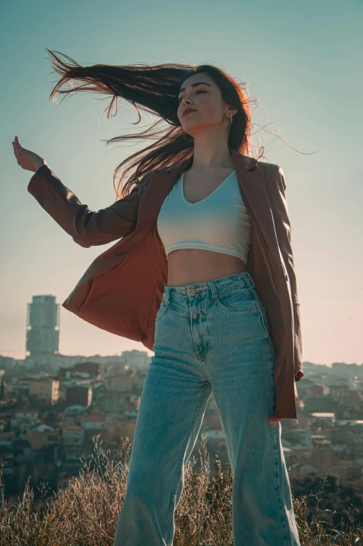 a woman standing on top of a field with her hair blowing