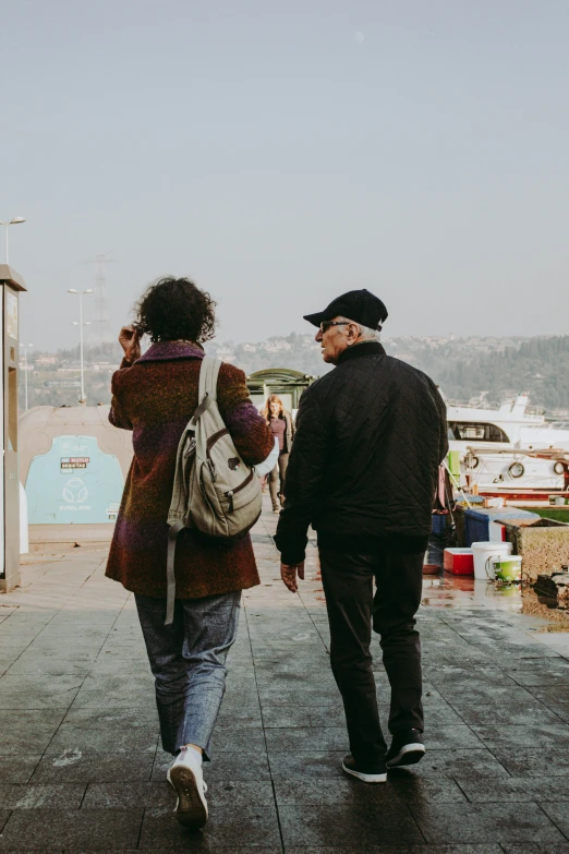 a woman walks with a man across a pier