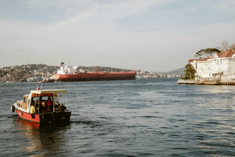 a tug boat is in the water passing a cargo ship