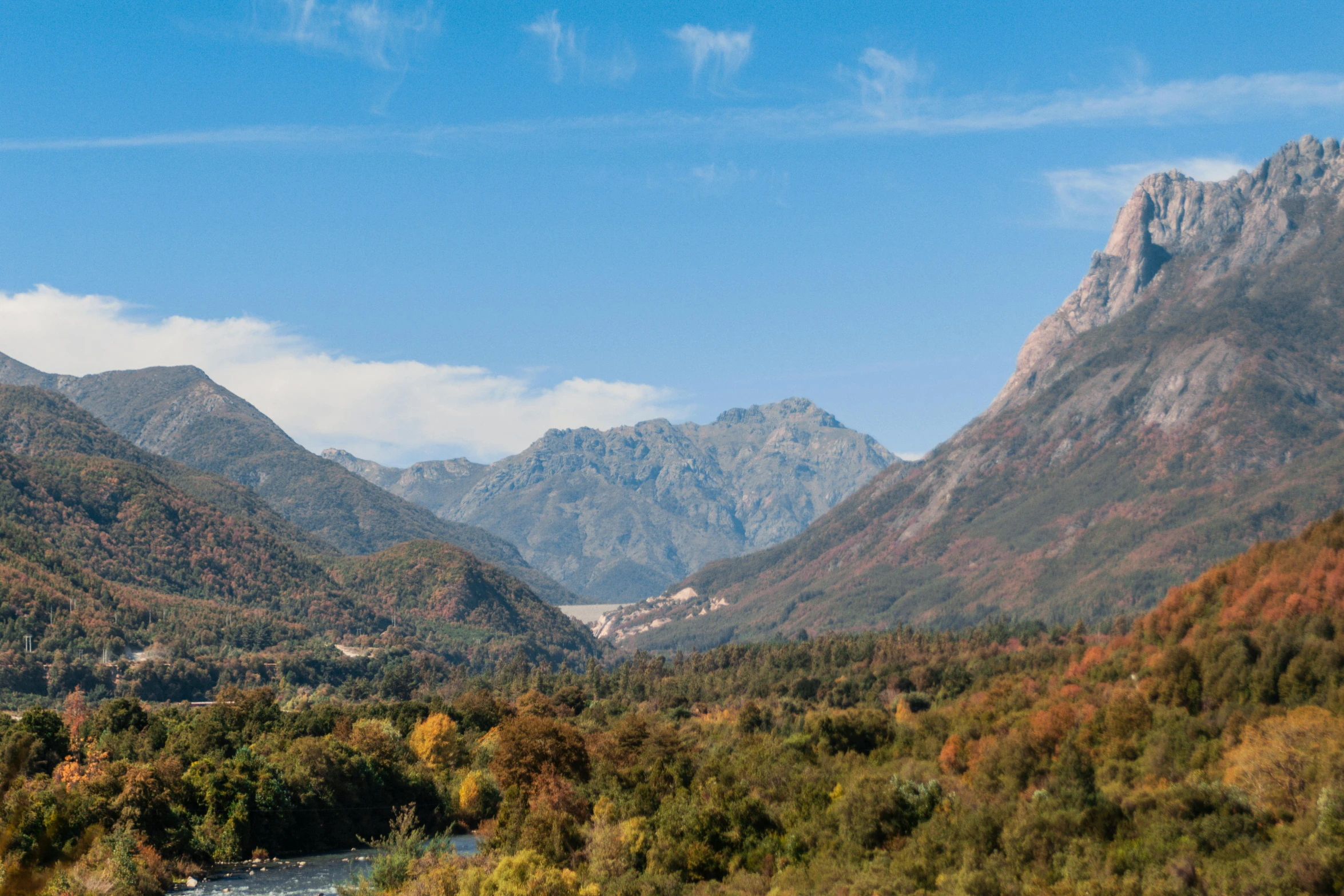 a scenic view of a mountain range with mountains in the background