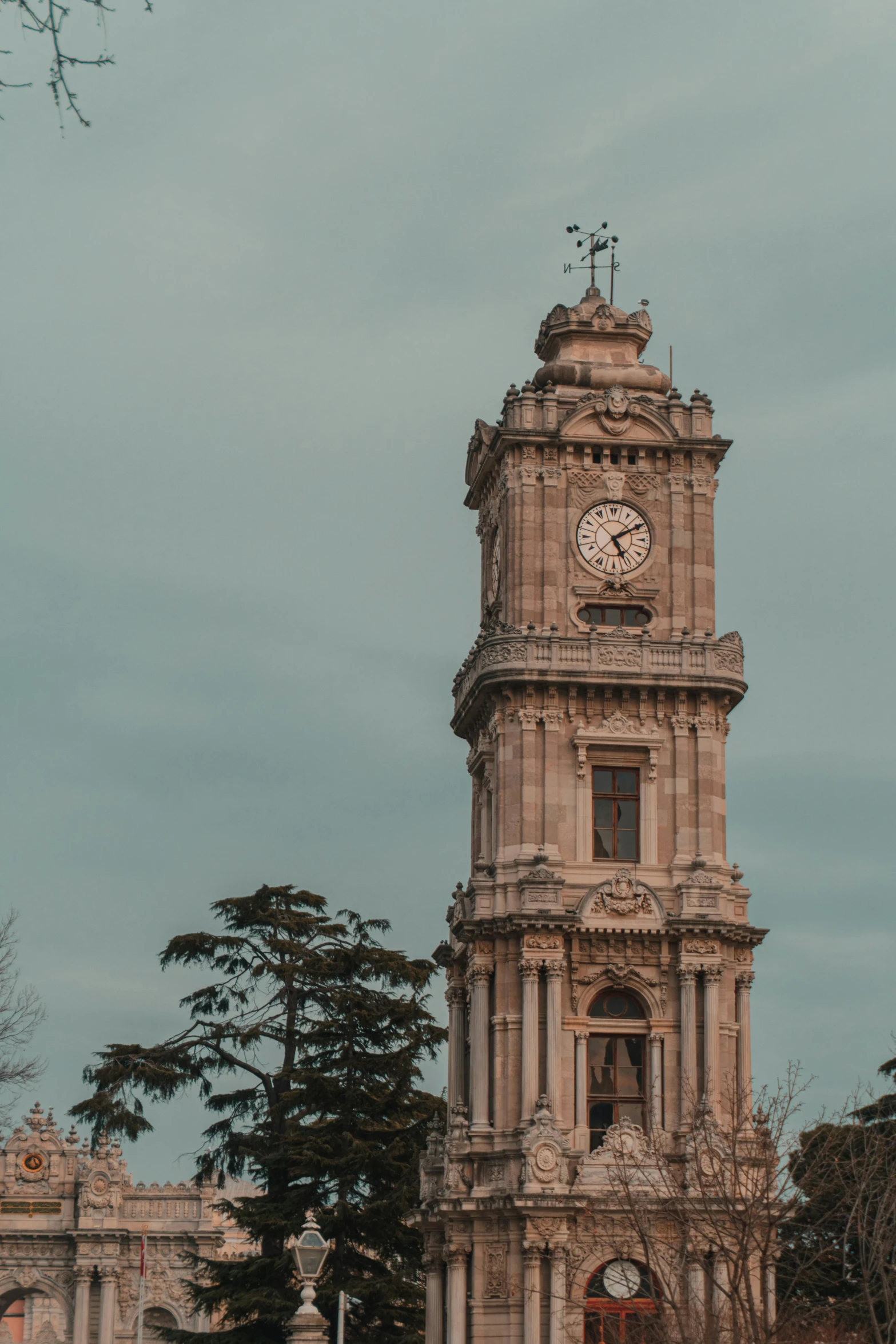 a large clock tower is shown against a gray sky